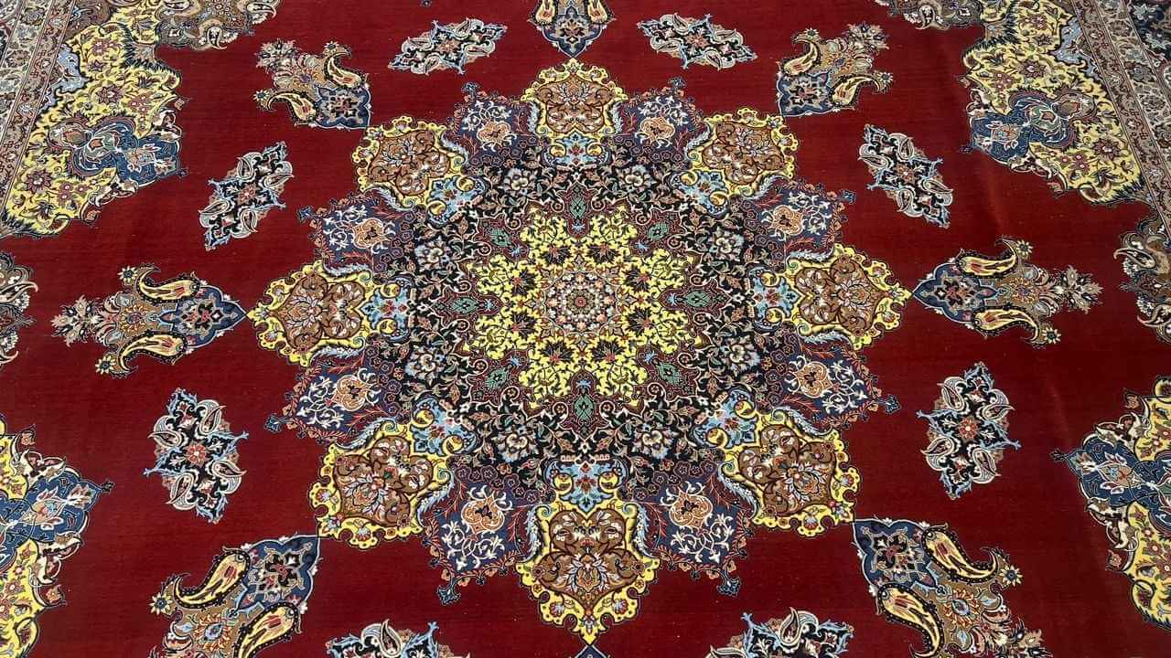 "Handwoven Persian rug by Master Bagher Seirafian, showcasing rich red, gold, and blue hues with a luxurious silk and wool blend."